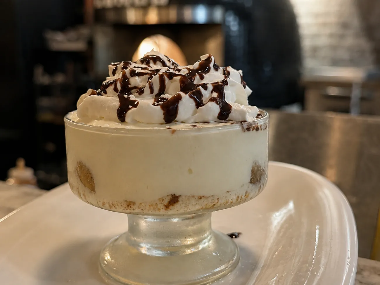House tiramisu topped with whipped cream and chocolate